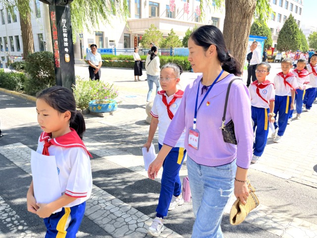 02 臨澤縣城關(guān)小學(xué)“紅燭先鋒”護學(xué)崗教師護送學(xué)生放學(xué)。謝靜 攝.jpg