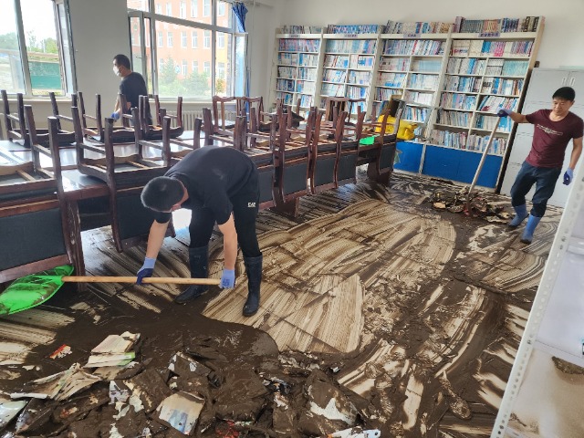 向陽鎮(zhèn)中心學校教師在清理淤泥。 李國彬 攝